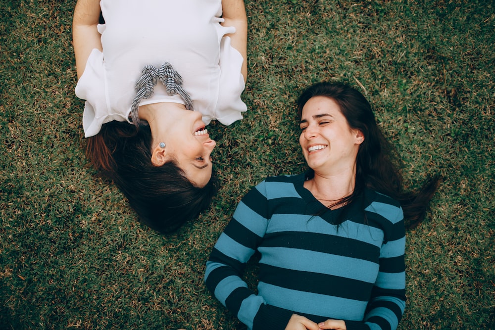 man in blue and black striped long sleeve shirt lying on green grass field