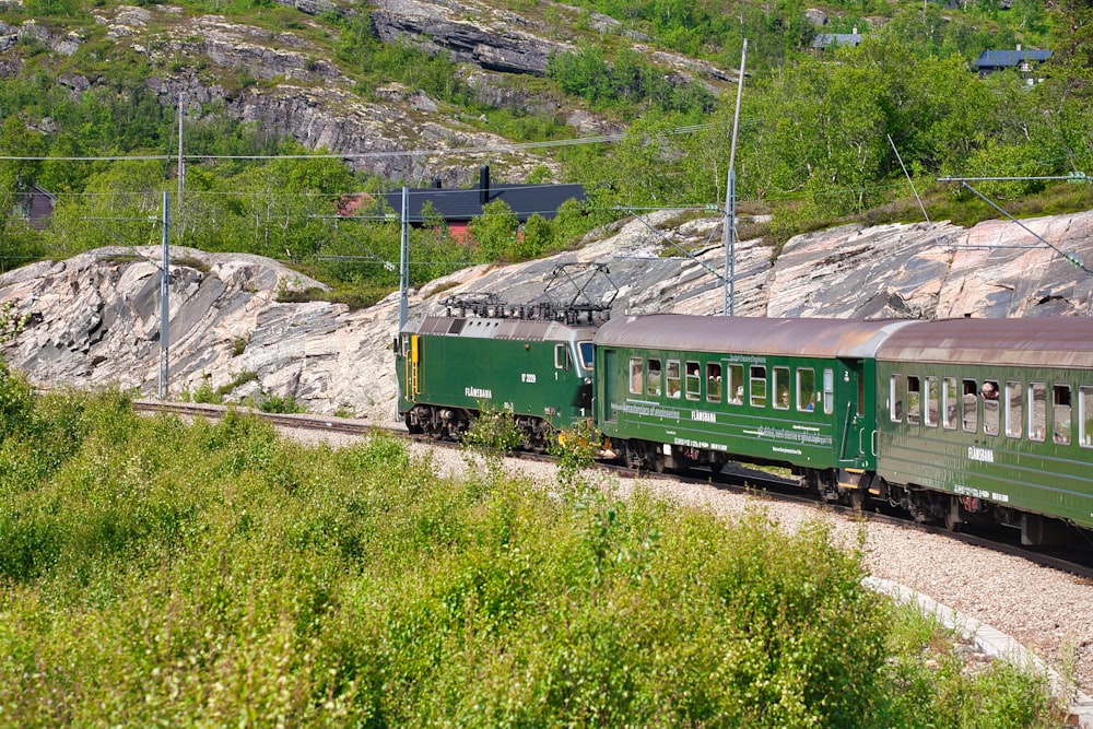 green train on rail tracks during daytime