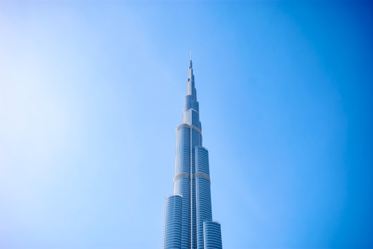 white concrete building under blue sky during daytime in The Dubai Fountain United Arab Emirates