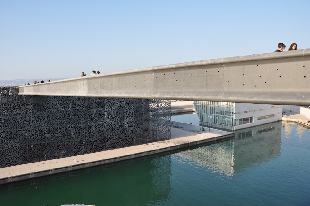 people walking on bridge over the river during daytime