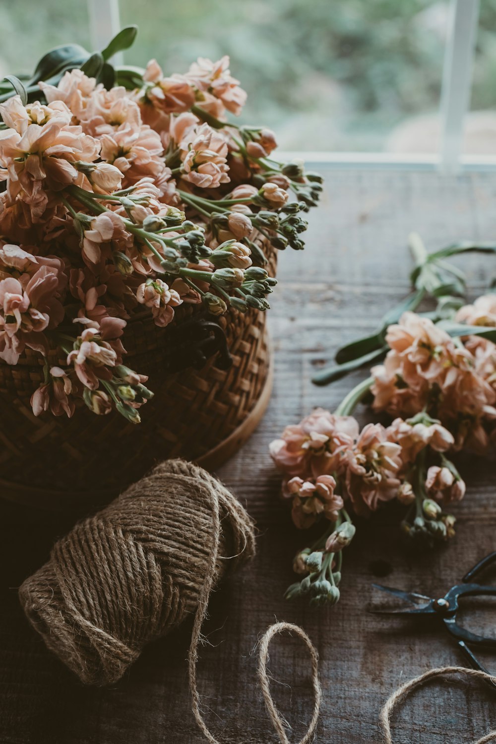 Bouquet di fiori marroni e bianchi su cesto di vimini marrone