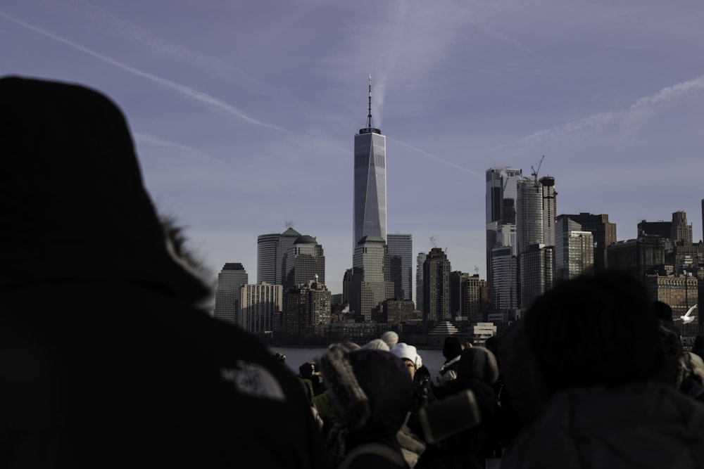 people sitting on the ground with high rise buildings in the distance