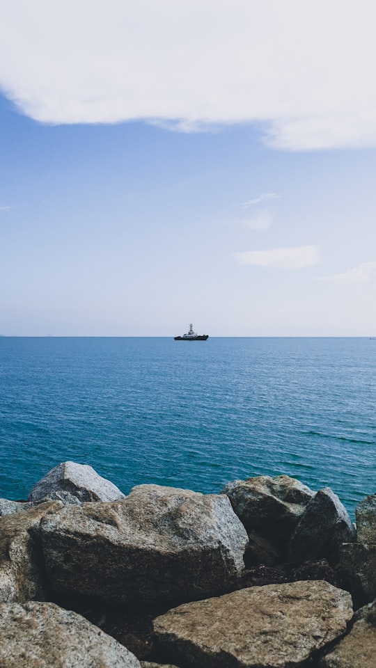 black ship on sea under blue sky during daytime in Port Dickson Malaysia