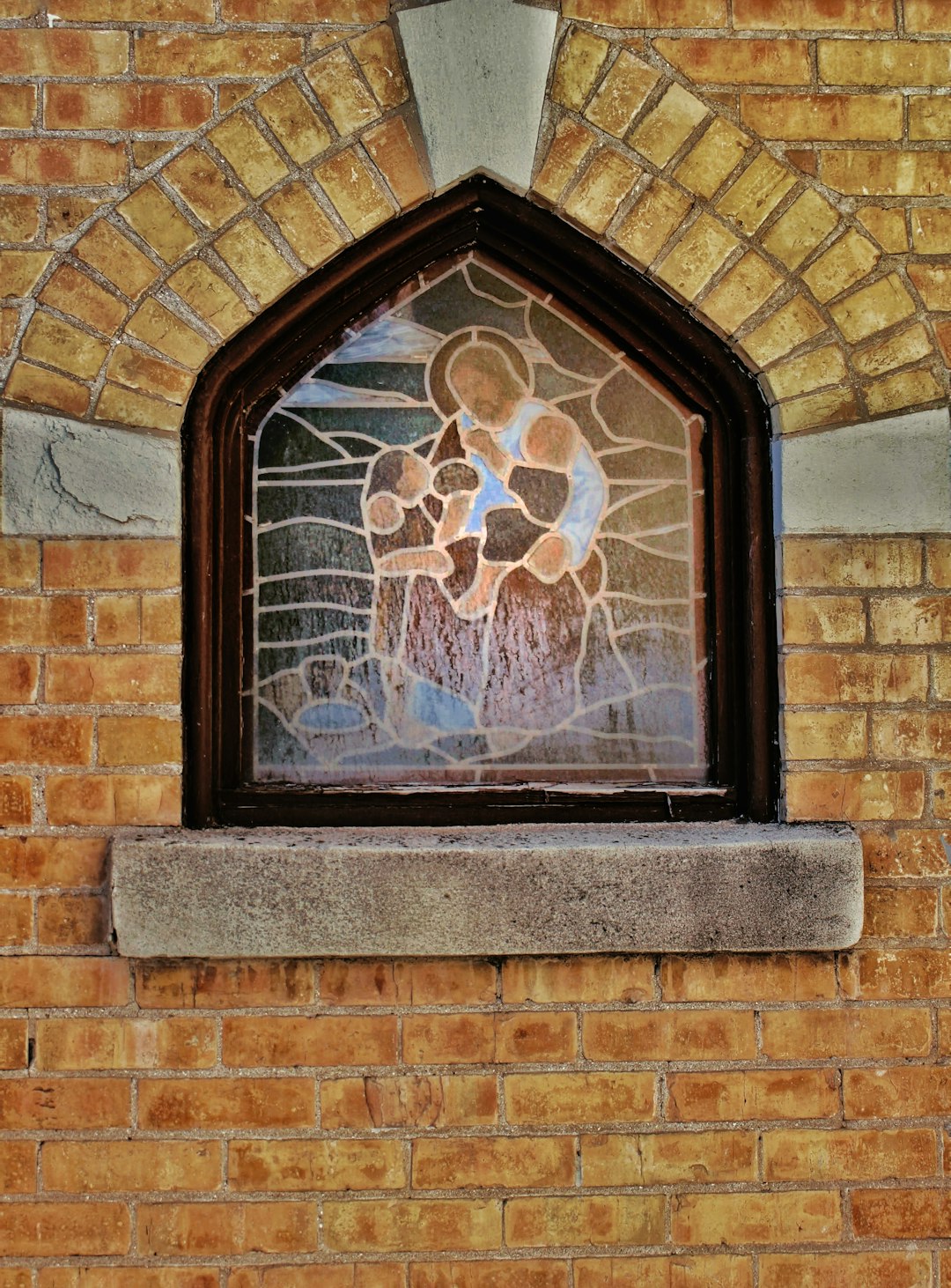black framed glass window on brown brick wall