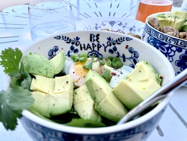 sliced green fruit on white and blue ceramic bowl
