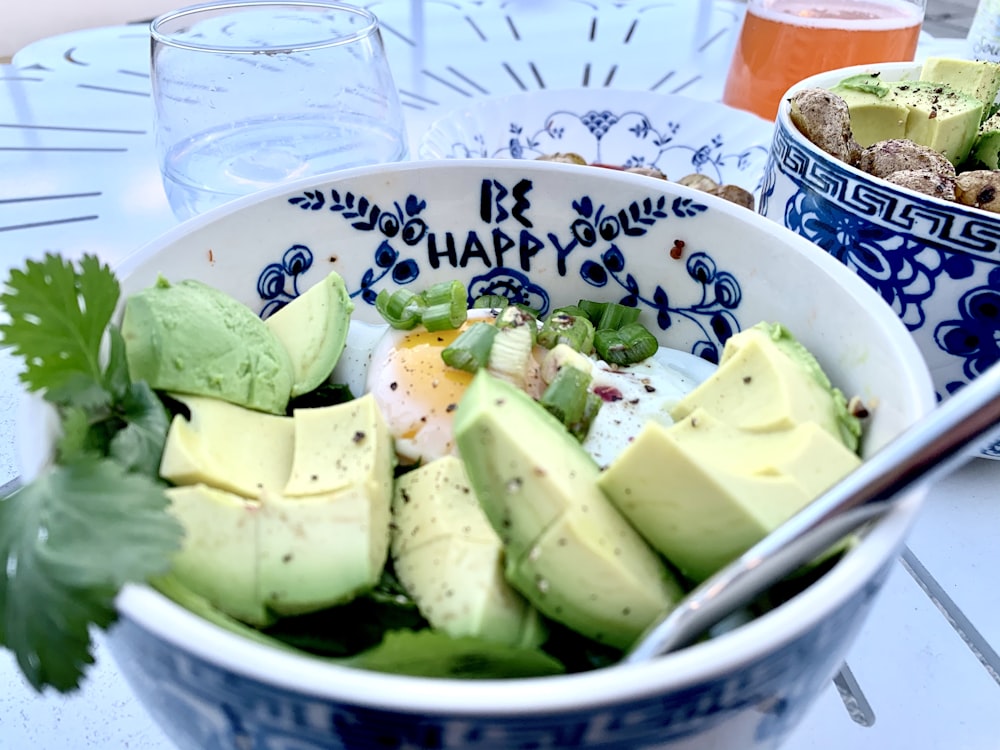 sliced green fruit on white and blue ceramic bowl