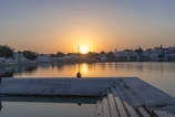 A peaceful scene of a person meditating by a calm lake at sunset.