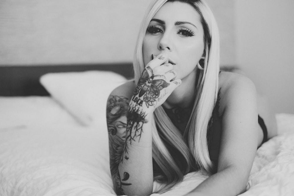grayscale photo of woman with tattoo on her right cheek