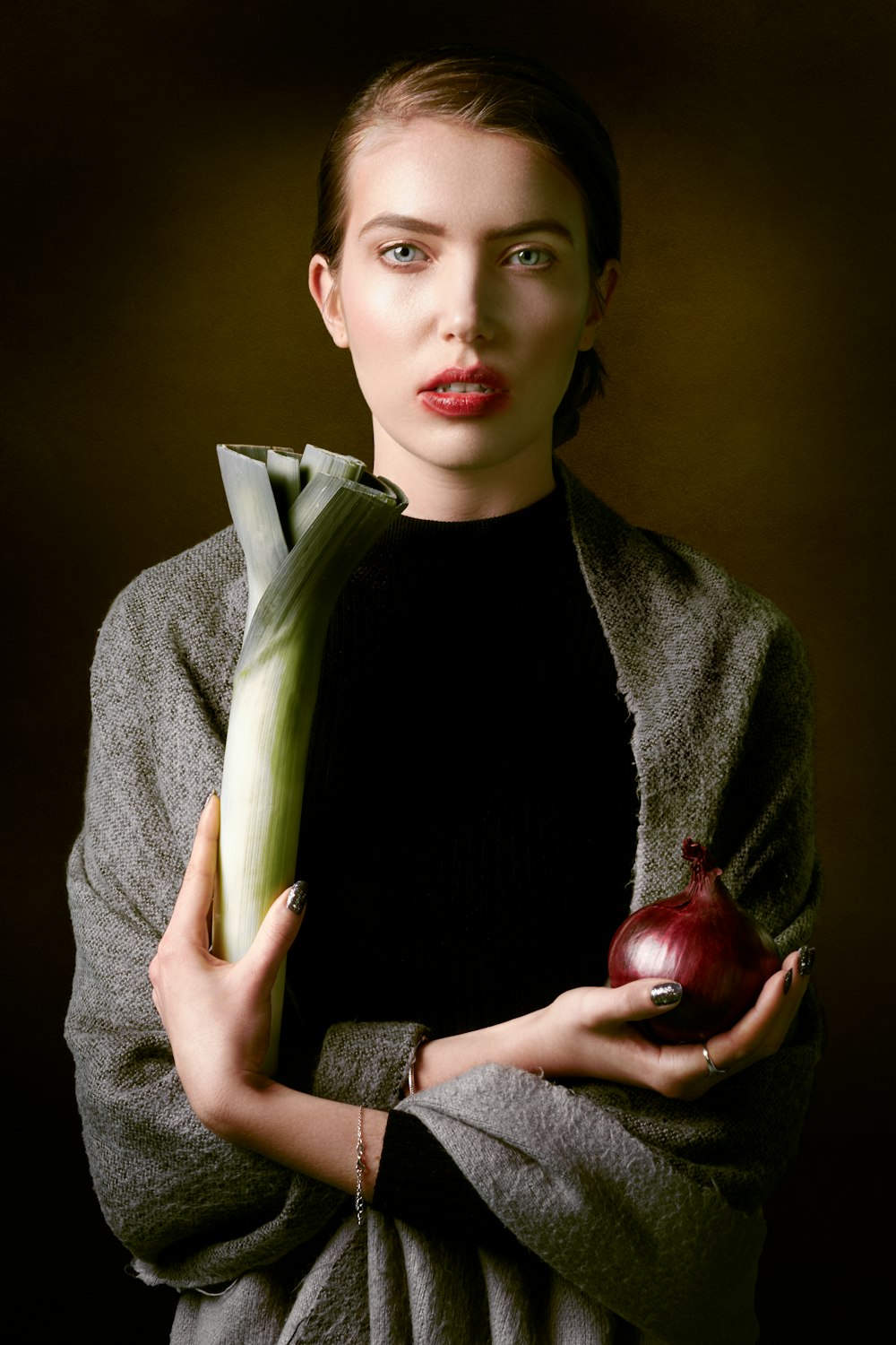 man in gray blazer holding red apple
