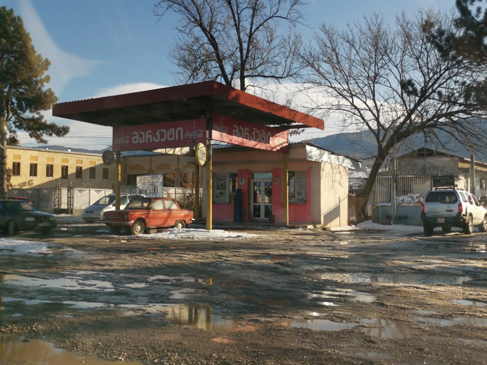 red and white concrete building near bare trees under blue sky during daytime