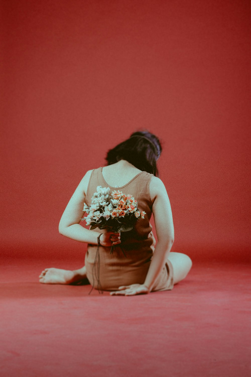 woman in white and red floral dress sitting on floor