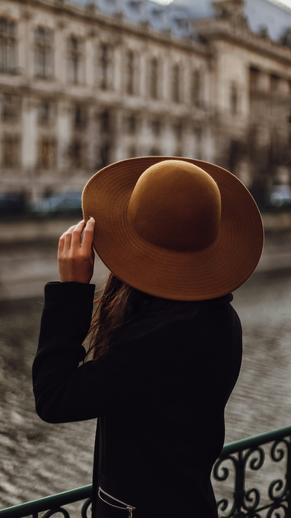 Femme en chemise noire à manches longues portant un chapeau marron