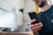 A close-up of a person checking their phone for delivery updates while sitting at a desk.