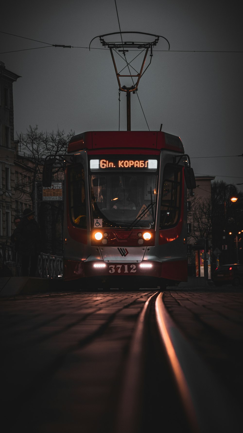夜間の道路を走る赤と黒の路面電車