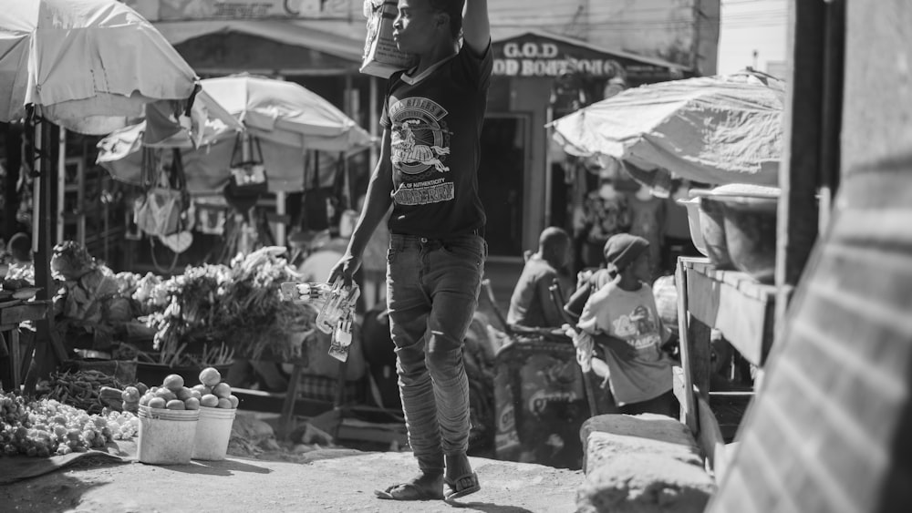 man in black t-shirt and blue denim jeans standing on street