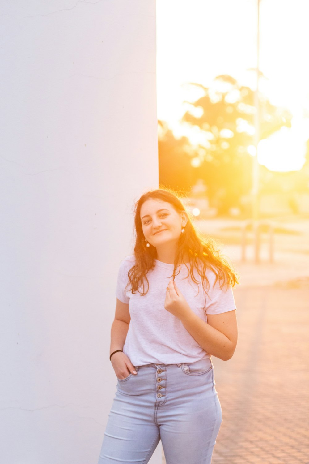 woman in white crew neck t-shirt standing beside white wall during daytime