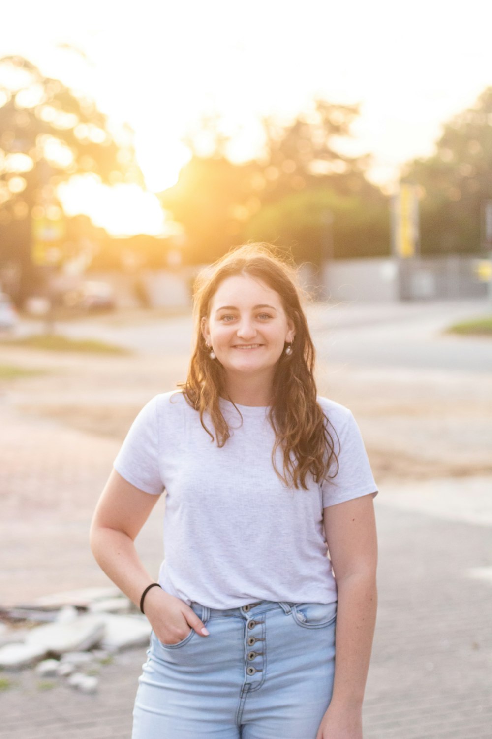 woman in white crew neck t-shirt standing on road during daytime