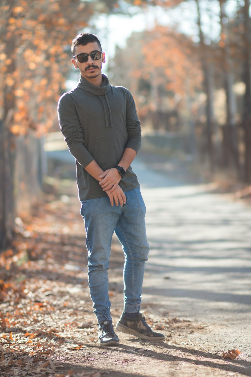 Hombre con camisa negra de manga y jeans azules parados en la carretera durante el día – Imagen Pueblo iraní gratis en Unsplash