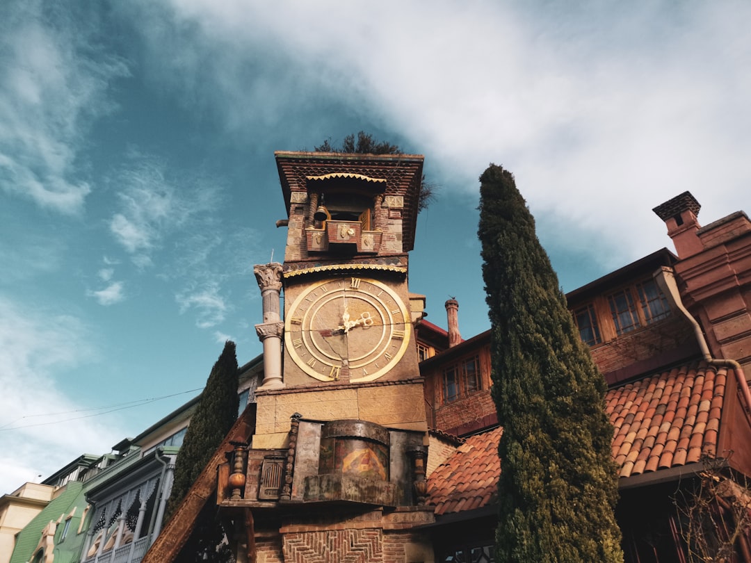 brown concrete building under cloudy sky during daytime, Tblisis, Georgia. The old tower rower.<p></figure>In 2010 Rezo Gabriadze built a unique clock tower next to marionette theatre in Tbilisi old town. Every hour an angel comes out with a small hammer to ring the bell.</p><p>Photo Max Letk @BlackprojectipnPhotography more below</p><p>https://medium.com/@maxipowers/tiblisis-quirky-clock-tower-83022272efed