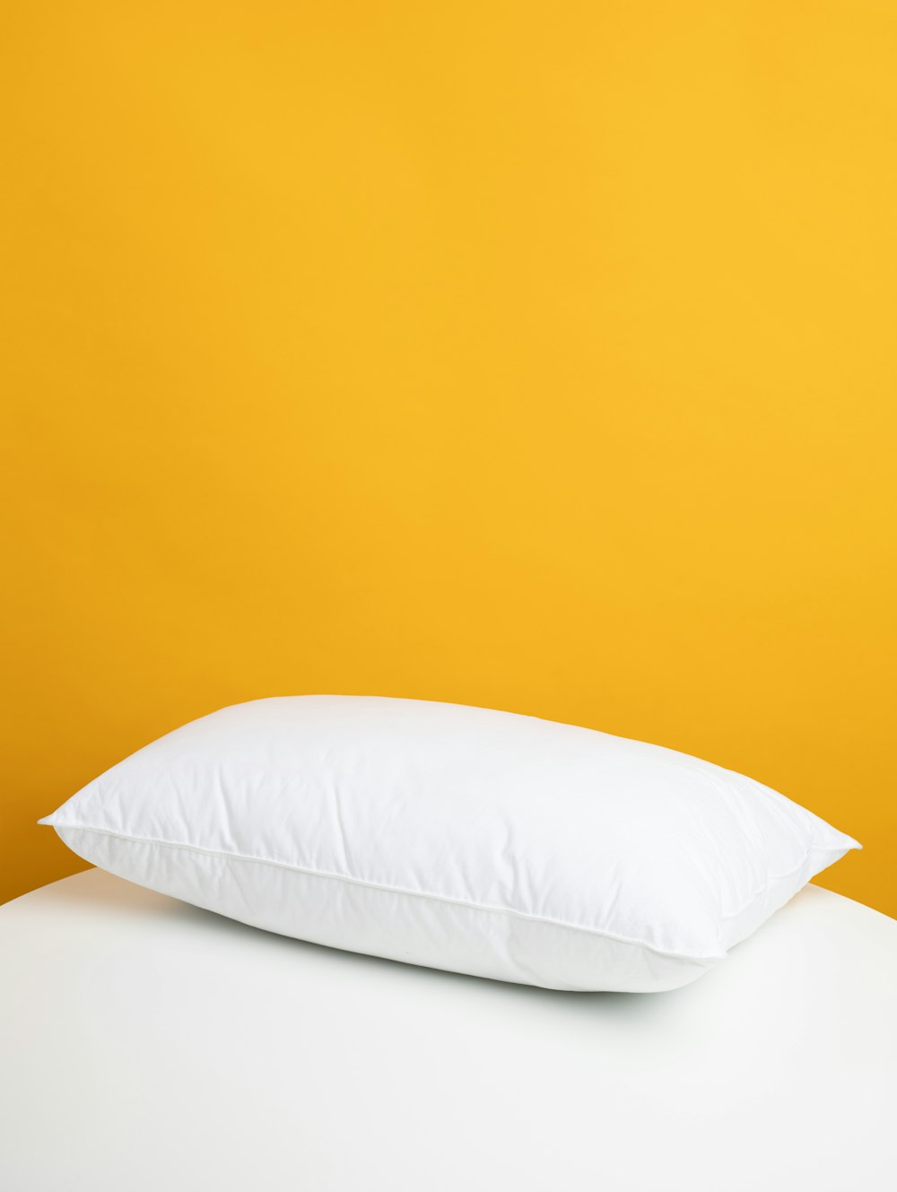 almohada blanca sobre cama blanca