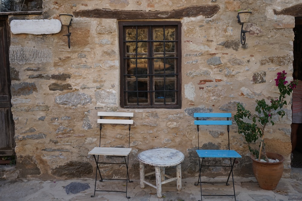 blue and white table and chairs beside brown brick wall