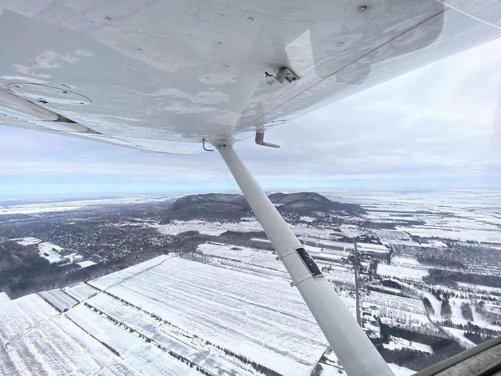 white airplane flying over snow covered mountains during daytime