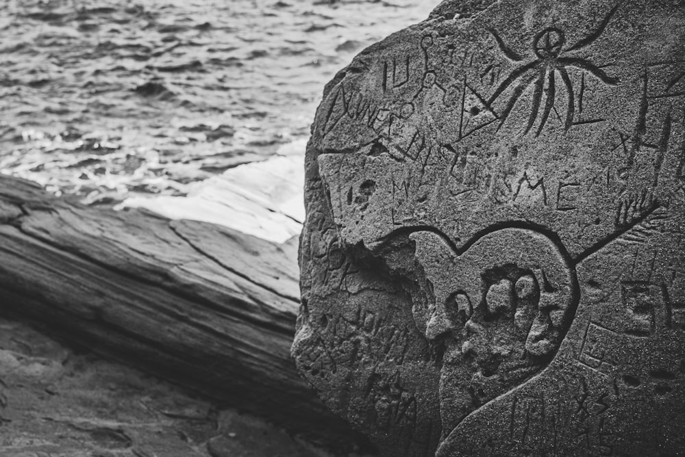 grayscale photo of mans face carved on wood