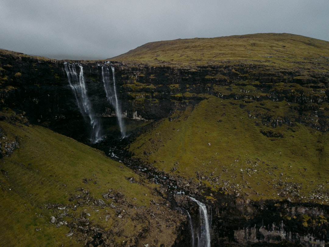 waterfalls on green grass field during daytime