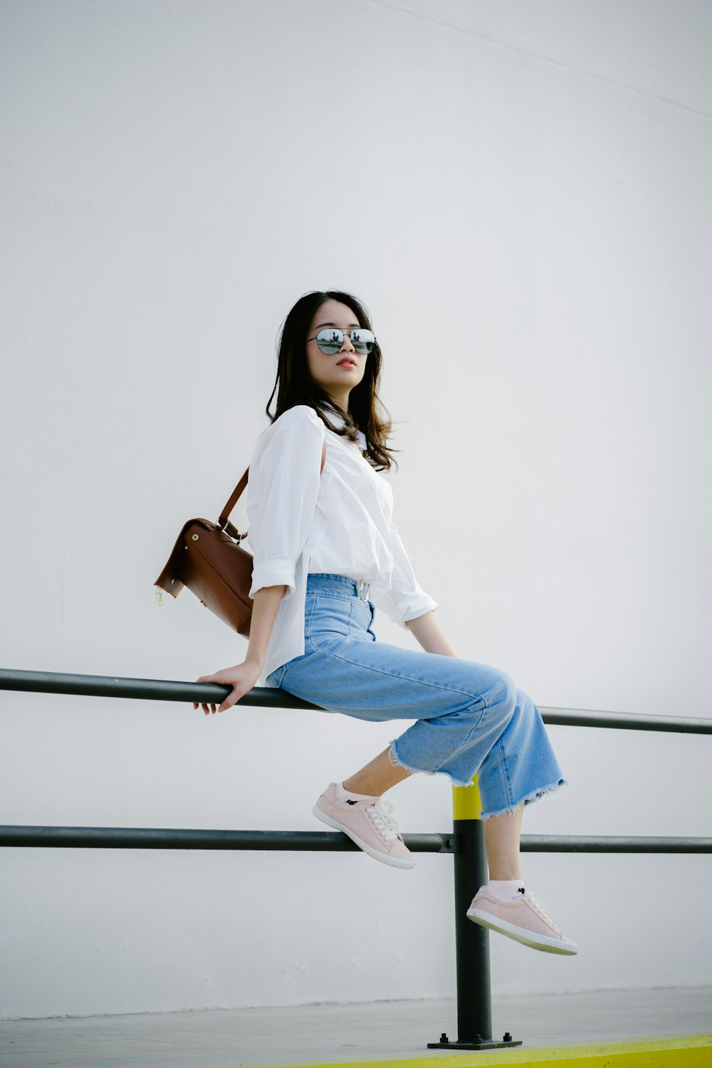 woman in white shirt and blue denim jeans sitting on white table