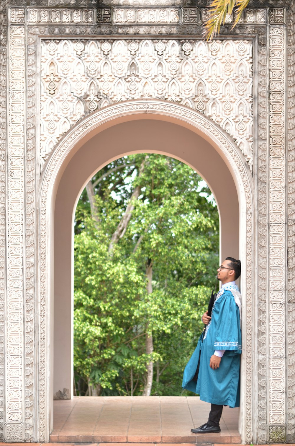 man in blue jacket standing near white and brown concrete building during daytime