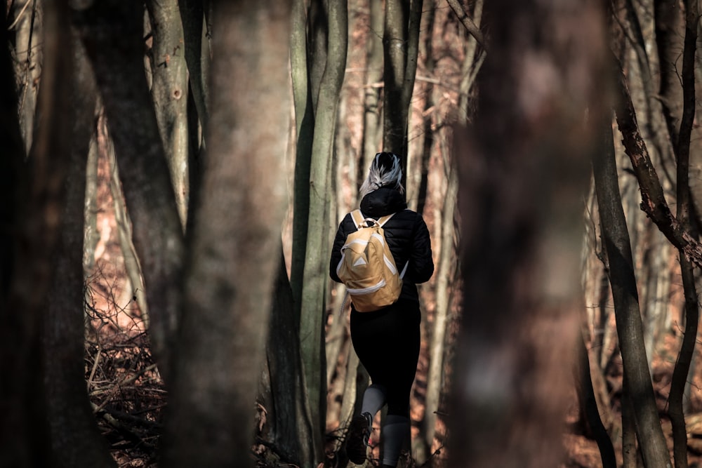 a person with a backpack walking through a forest