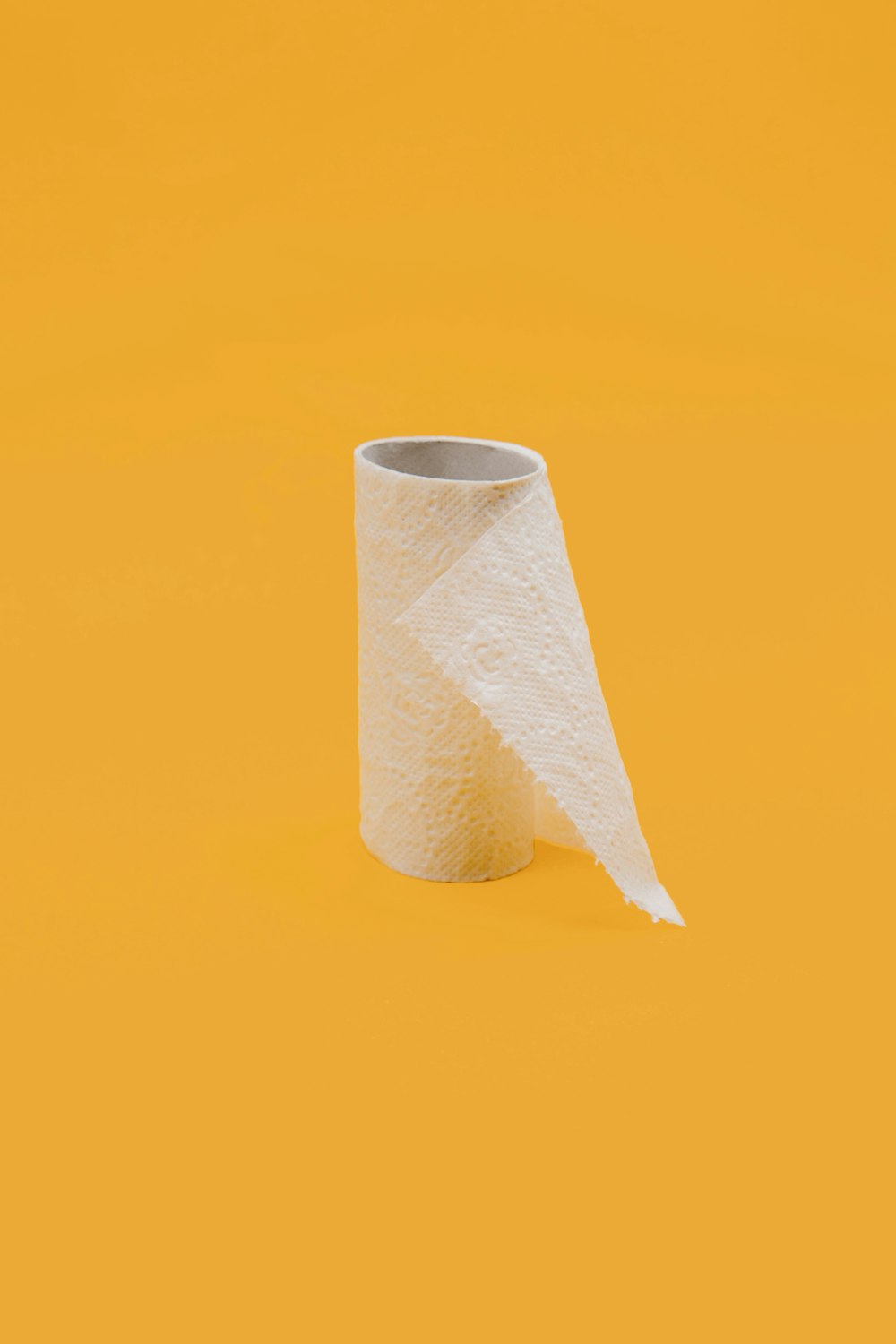 rollo de papel de seda blanco sobre superficie amarilla