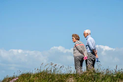 man in white dress shirt and black pants standing beside woman in black and white striped