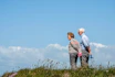 man in white dress shirt and black pants standing beside woman in black and white striped