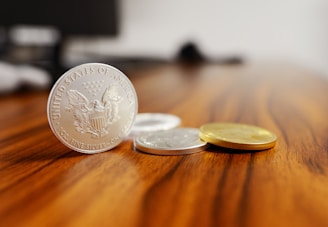 silver round coins on brown wooden table
