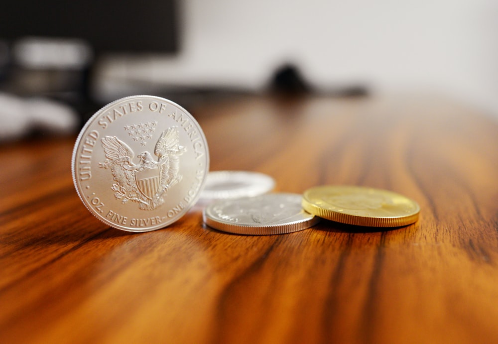 Monedas redondas de plata sobre mesa de madera marrón