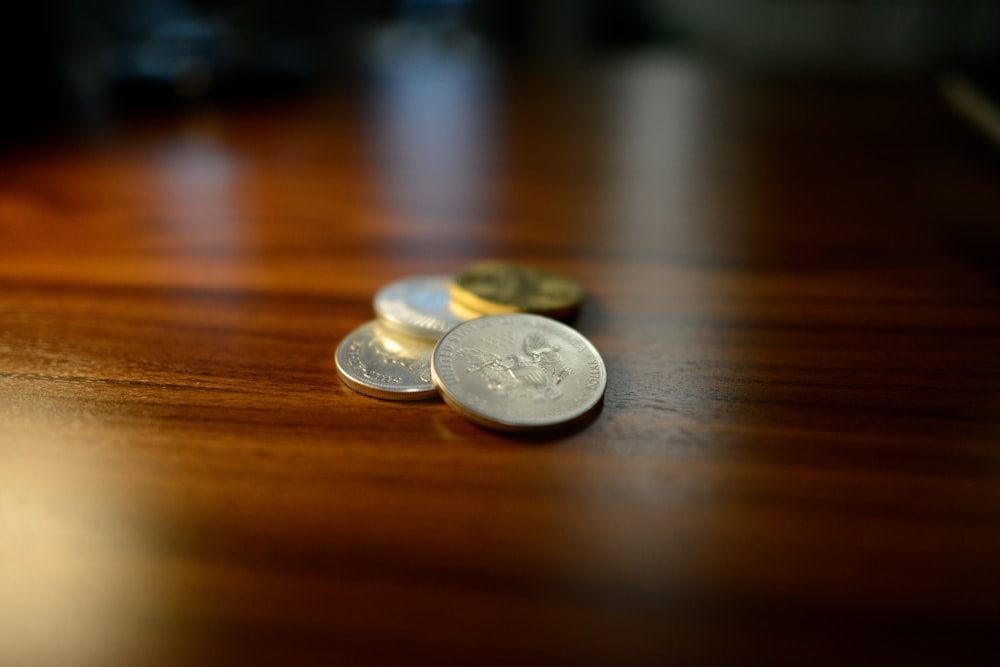 silver round coins on brown wooden table
