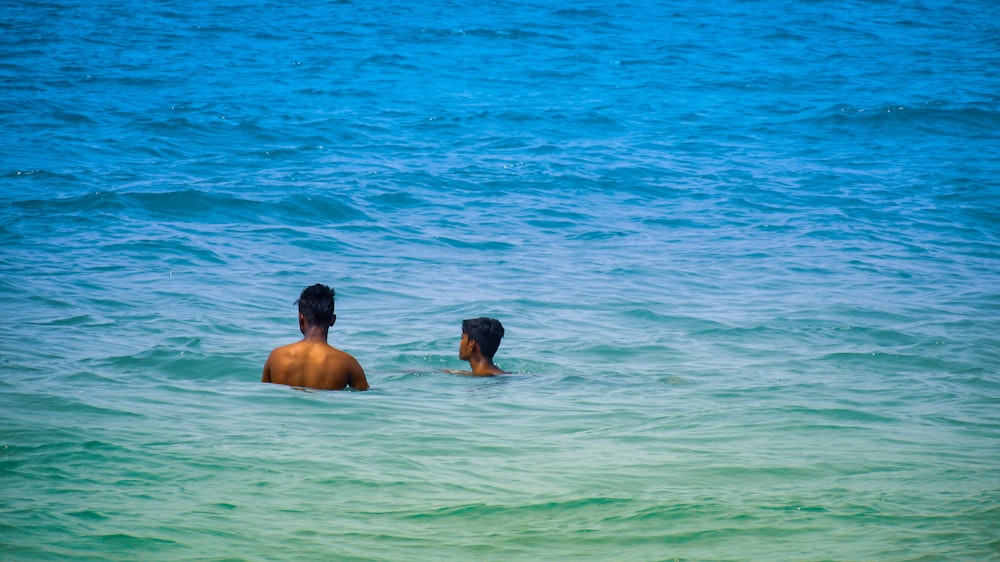 man and woman in body of water during daytime