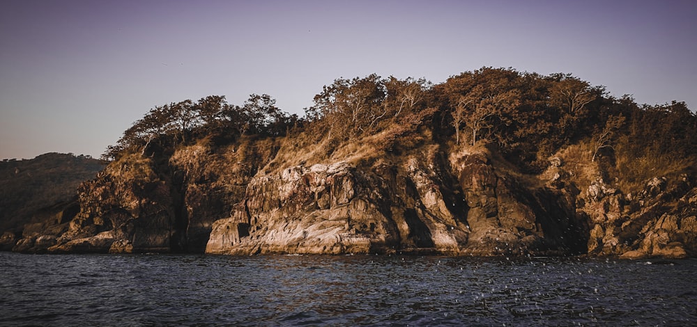 brown and green mountain beside body of water during daytime