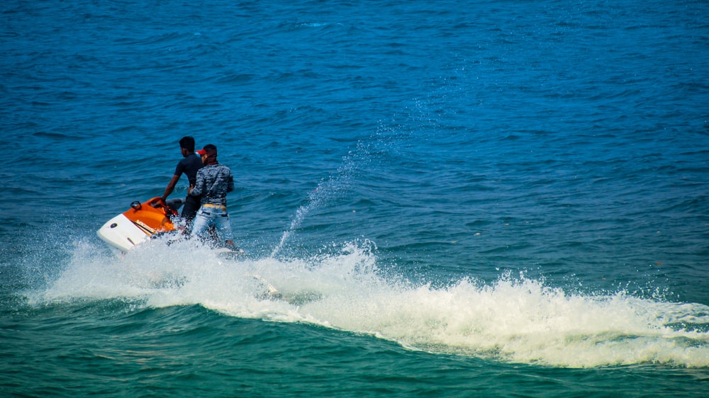 2 men surfing on sea during daytime