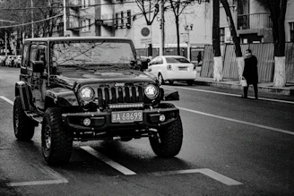 A stylish black Jeep Wrangler converted into a cozy mobile coffee shop, parked on a city street with a stone beige awning.
