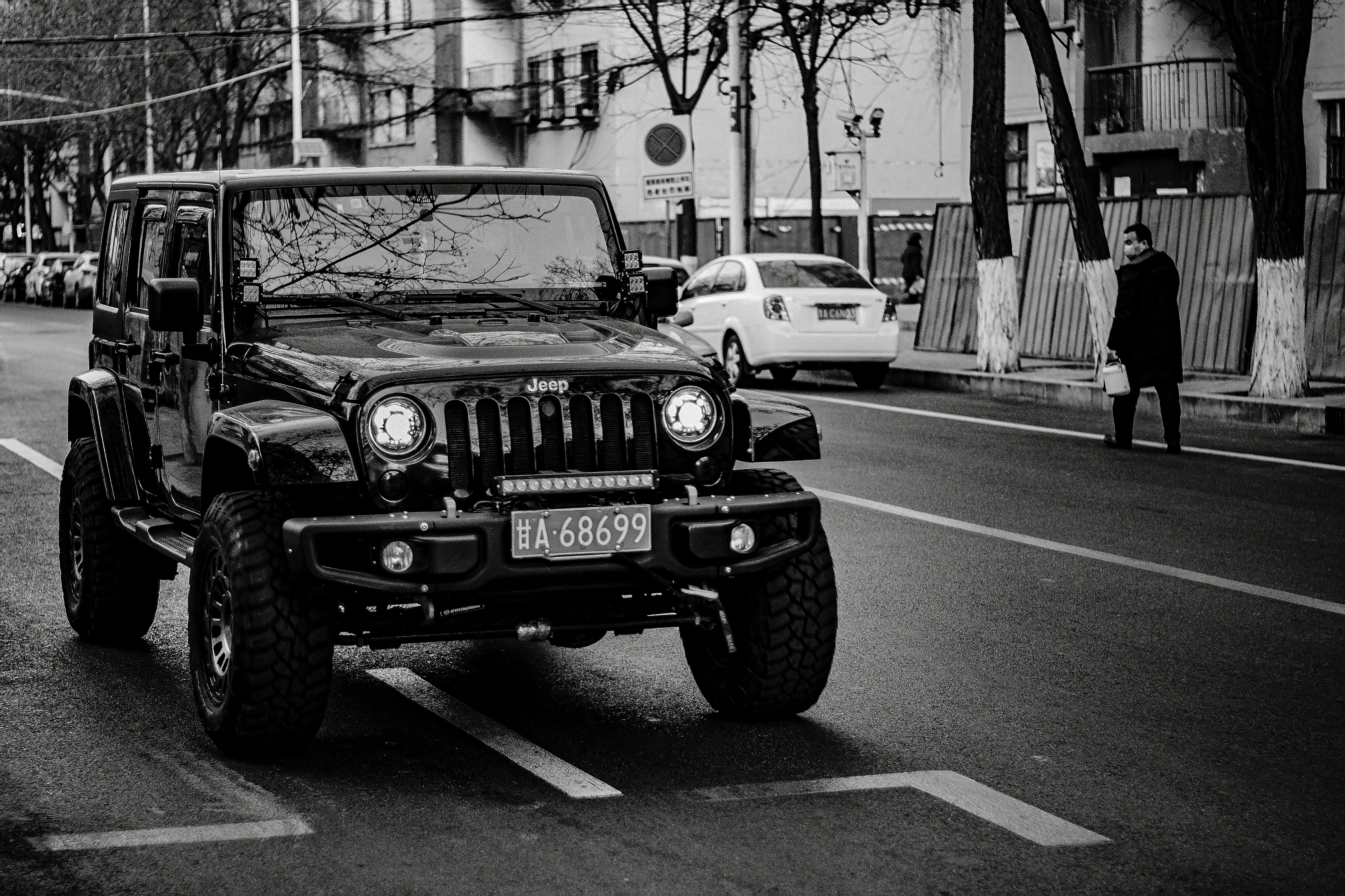 grayscale photo of jeep wrangler on road
