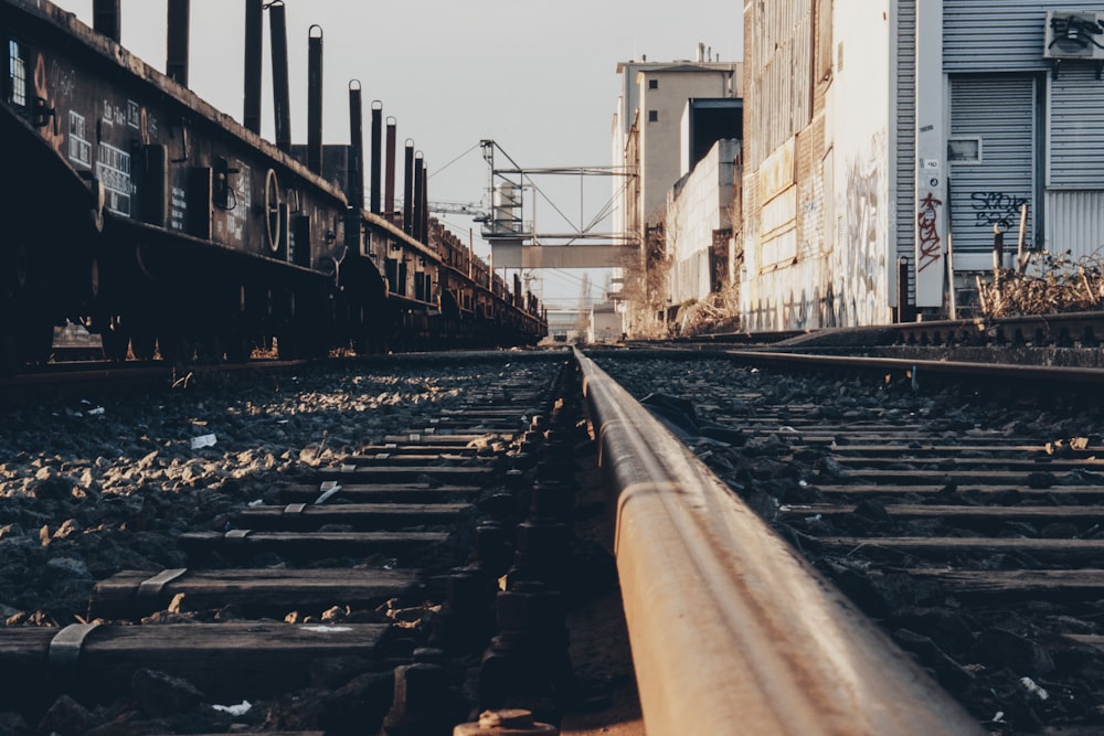 black metal train rail near white concrete building during daytime