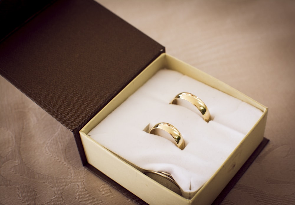 gold ring in box on white textile