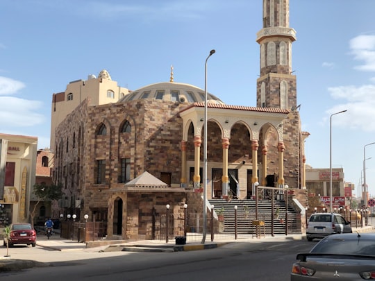 cars parked in front of brown concrete building during daytime in Hurghada - Safaga Road Egypt