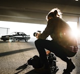 Photographer inspecting a vehicle used as collateral in a sunny parking lot.