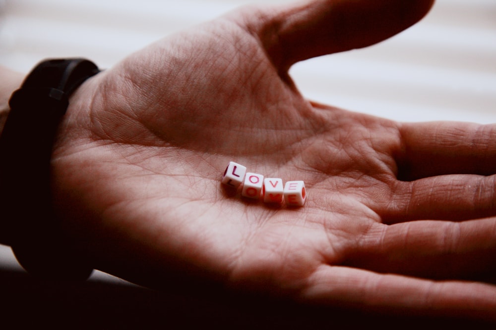 red and white plastic toy on persons hand