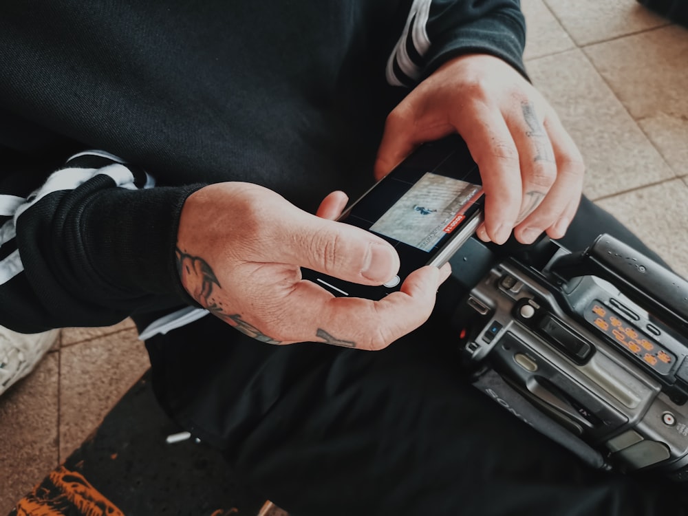 person holding black iphone 4