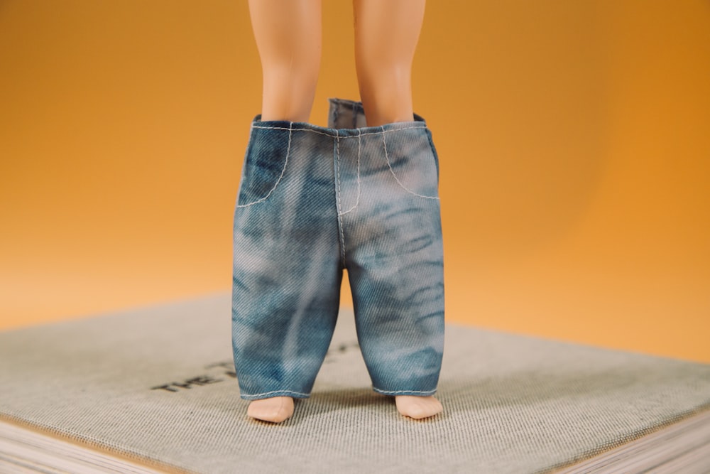 woman in blue denim jeans standing on brown carpet