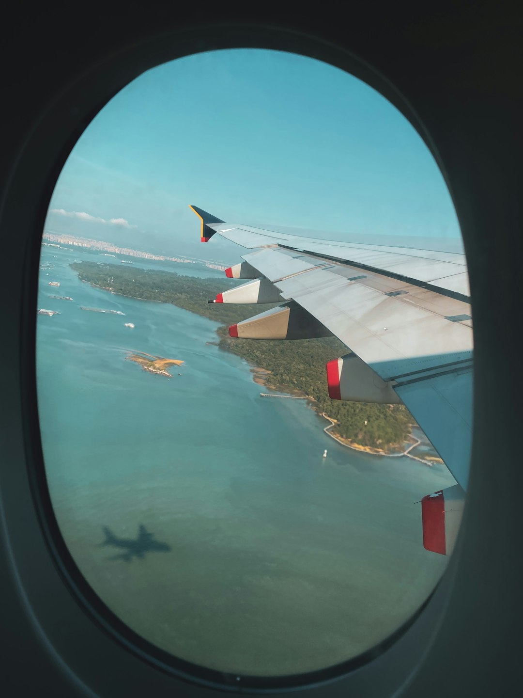 white airplane wing over body of water during daytime